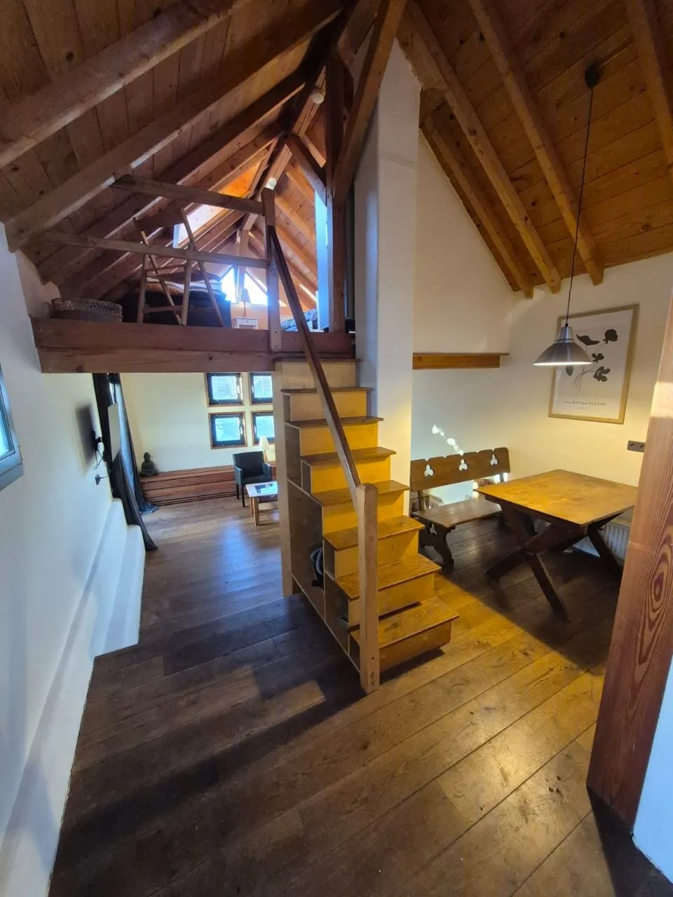 Wohnung mit Galerie, Holztreppe und Essbereich unter dem offenen Dachstuhl