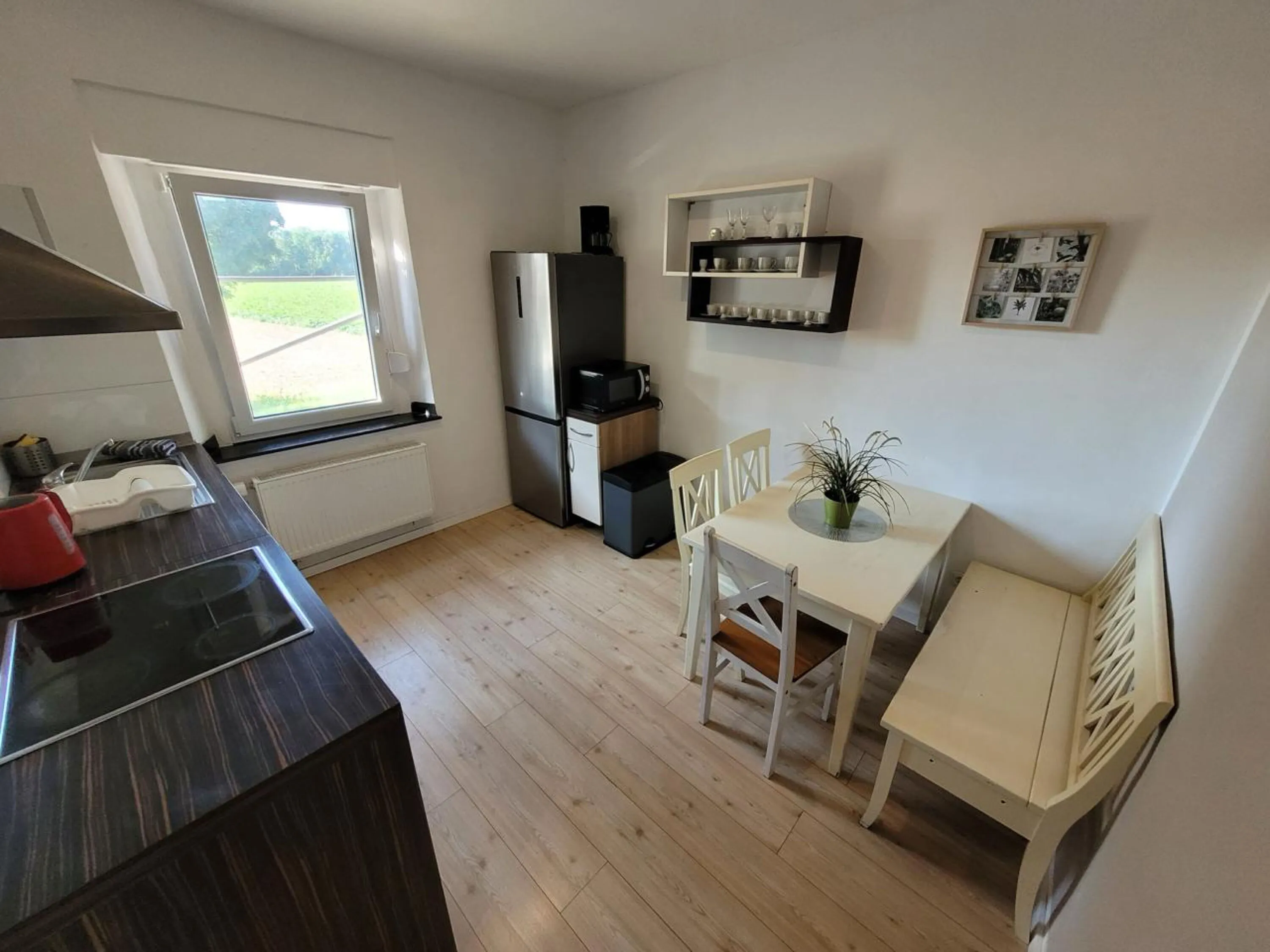 Voll ausgestattete Küche mit Essbereich und Fenster zum Garten